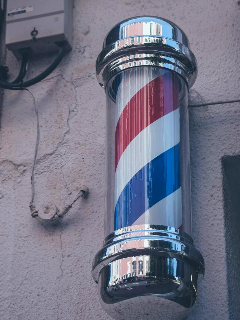 A red, white, and blue barber pole mounted on a wall.